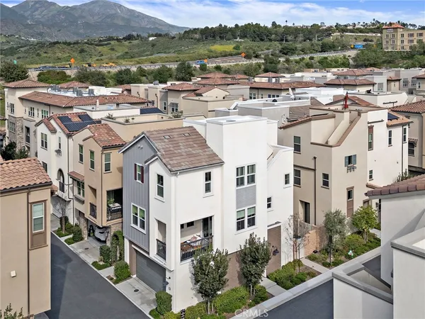 a view of a white house with a yard and potted plants