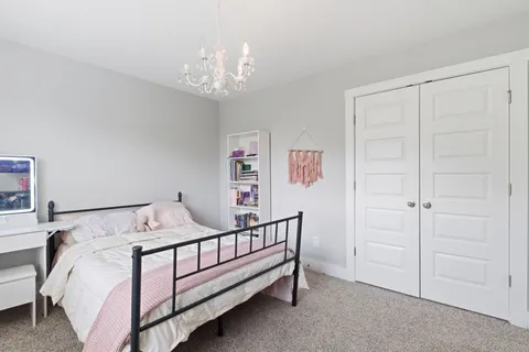 a bedroom with a bed and a chandelier