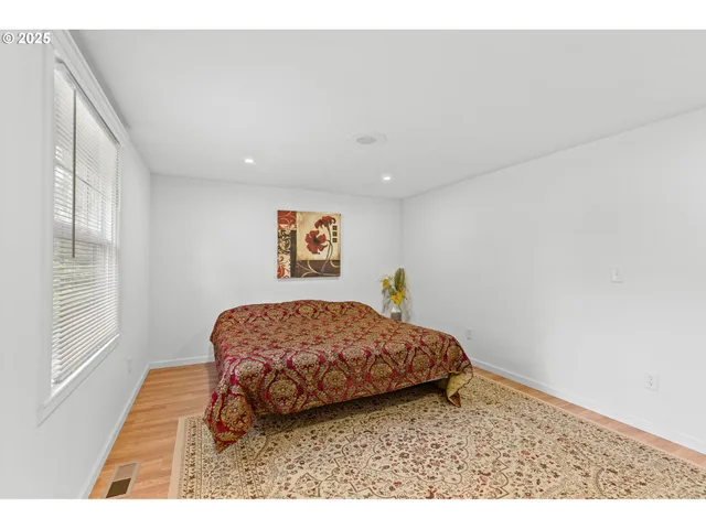 a bedroom with a bed and a flat tv screen on the dresser