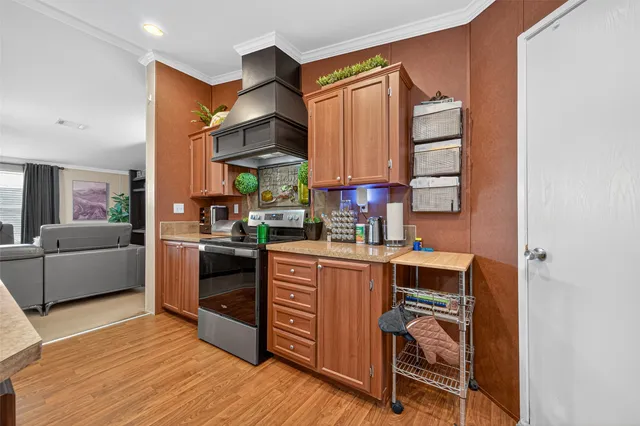 a kitchen with stainless steel appliances a sink cabinets and wooden floor