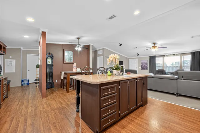 a large kitchen with stainless steel appliances granite countertop a lot of counter space and wooden floors