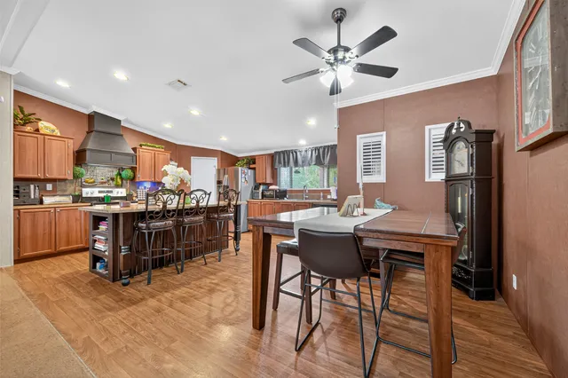 a room with stainless steel appliances kitchen island granite countertop furniture and a dining table