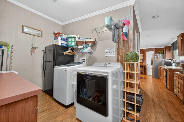 a utility room with wooden floor washer and dryer