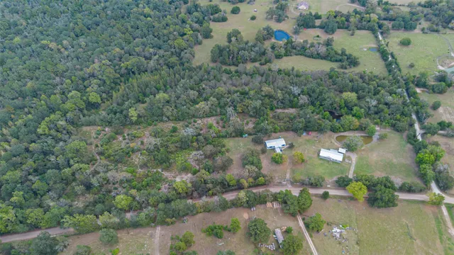 an aerial view of residential houses with outdoor space and trees