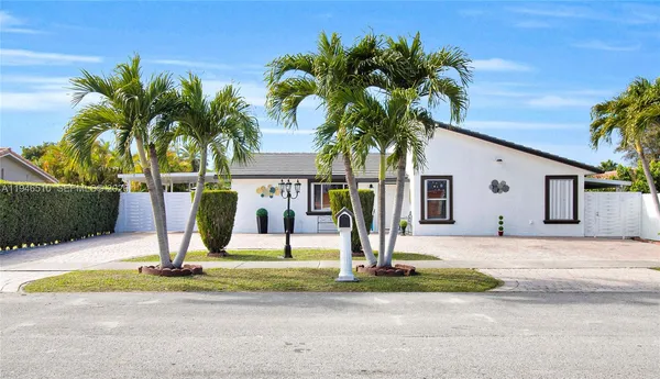 a view of a house with backyard and palm tree