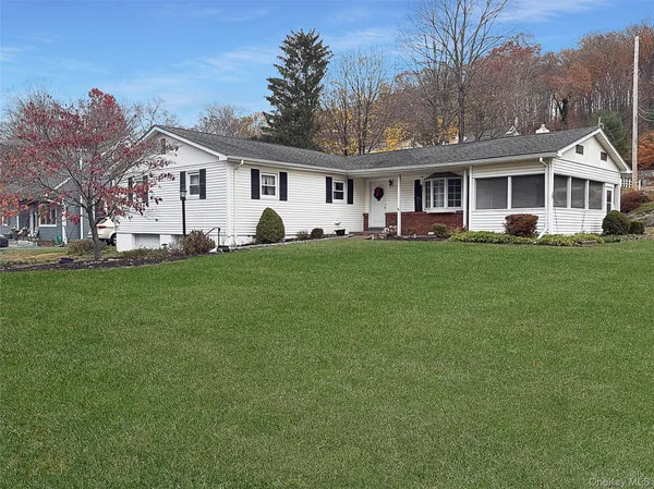a front view of a house with a garden and trees