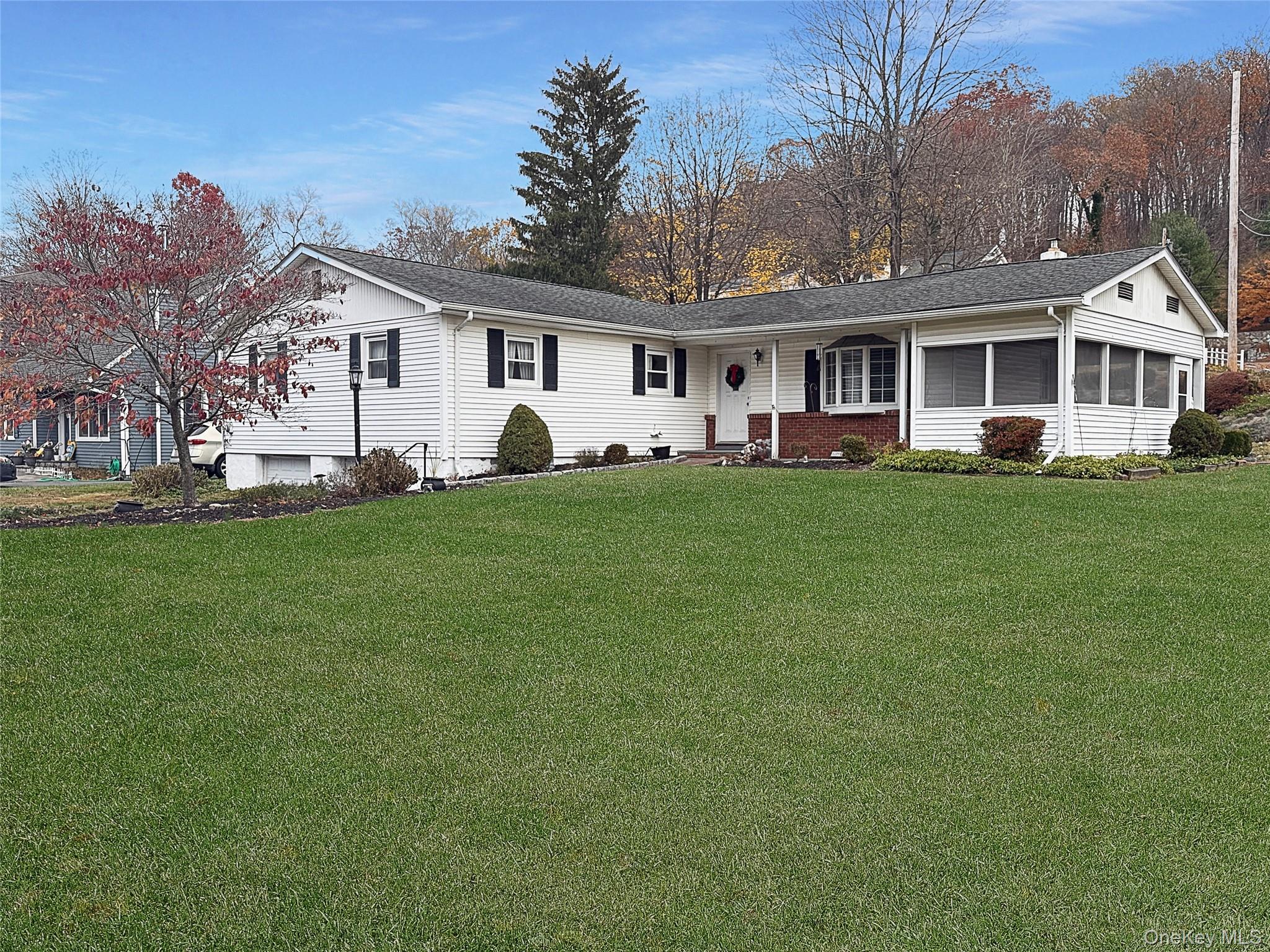 a front view of a house with a garden and trees