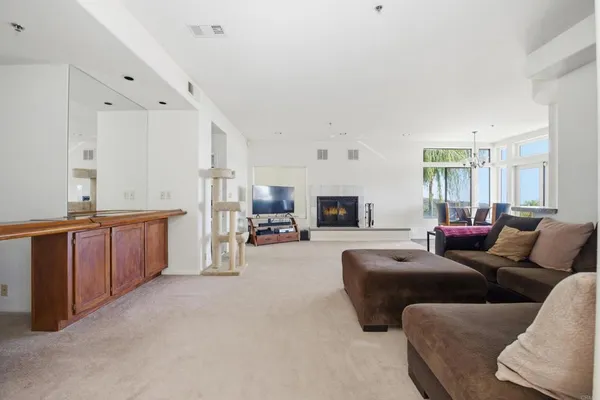 a living room with furniture a flat screen tv and kitchen view