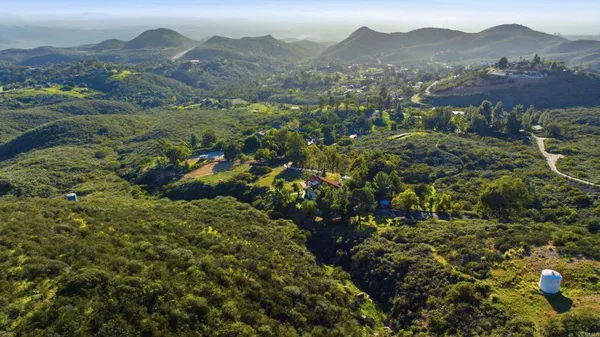 a view of a lush green hillside and houses