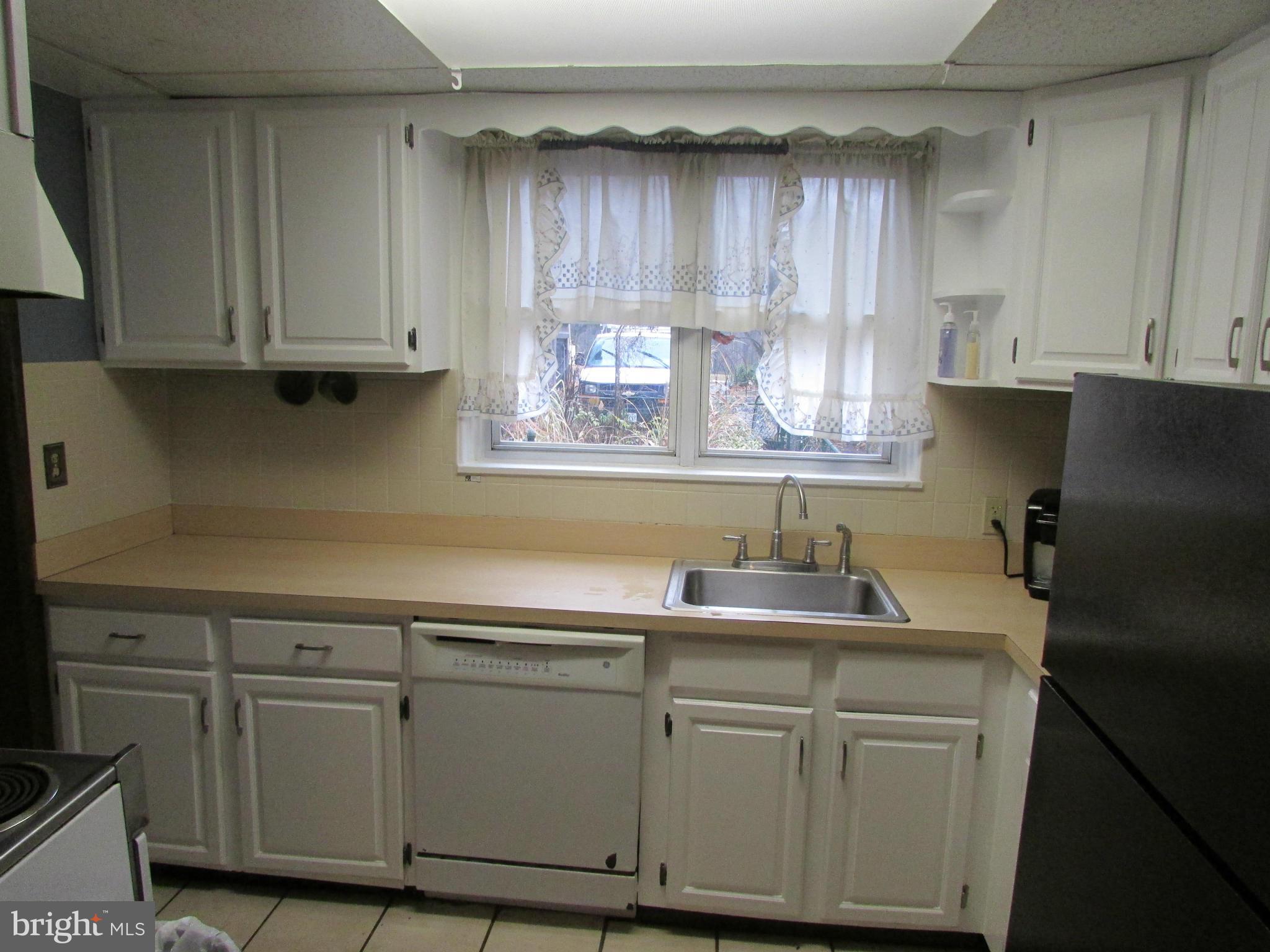 39 Ridge Road, Unit F Greenbelt, MD 20770 - Photo 5 of 14 a kitchen with stainless steel appliances granite countertop white cabinets sink and a granite counter top