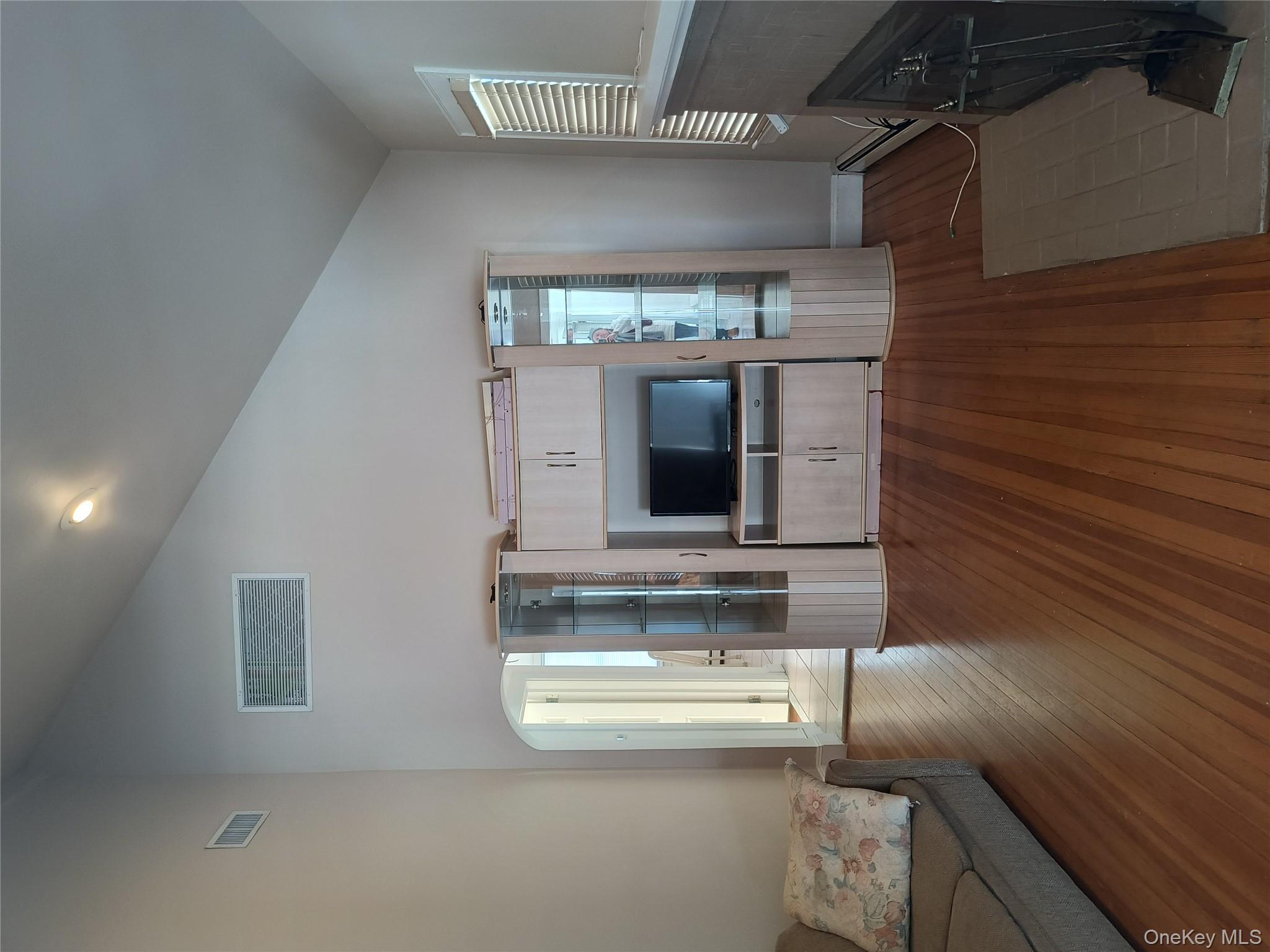 25 July Walk Long Beach, NY 11561 - Photo 10 of 15 Living room with high slanted ceiling and entertainment cabinet.