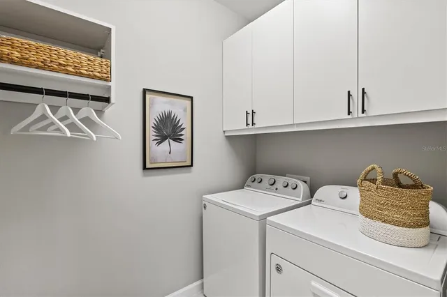 a view of a bathroom with a sink a chandelier and a mirror