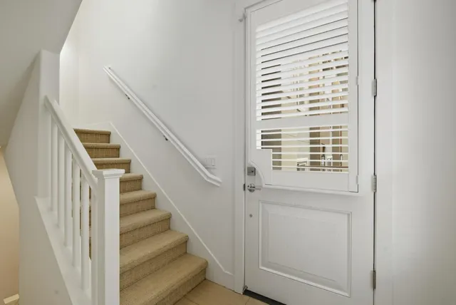 a view of staircase with wooden floor and white walls