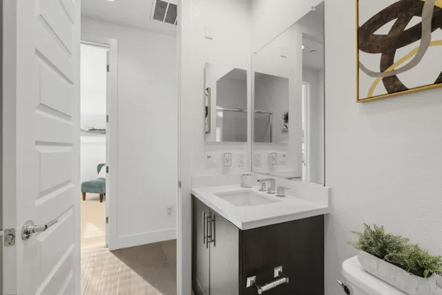 a bathroom with a sink a mirror a vanity and a shower