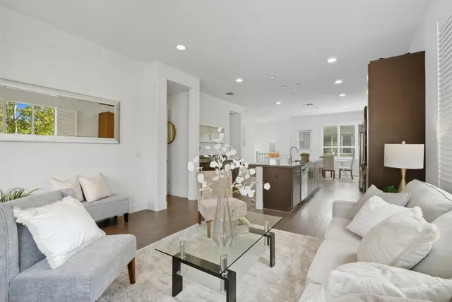 a living room with furniture and a view of kitchen
