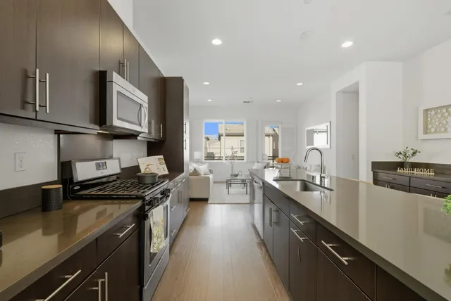 a kitchen with stainless steel appliances sink stove microwave and cabinets