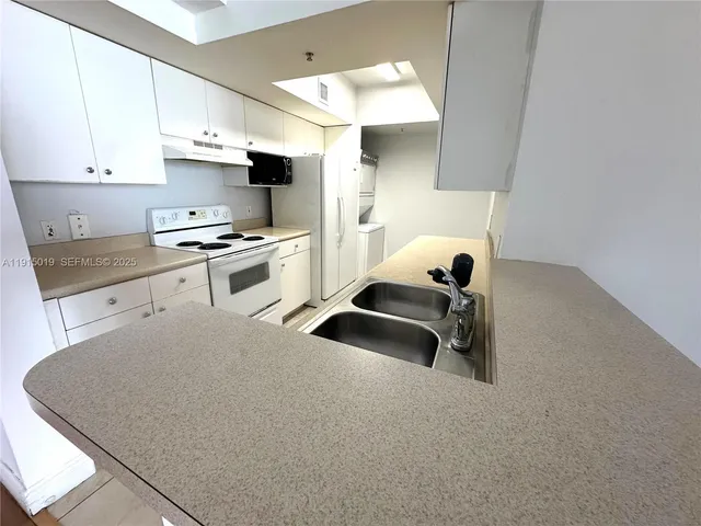 a kitchen with a sink a stove and cabinets