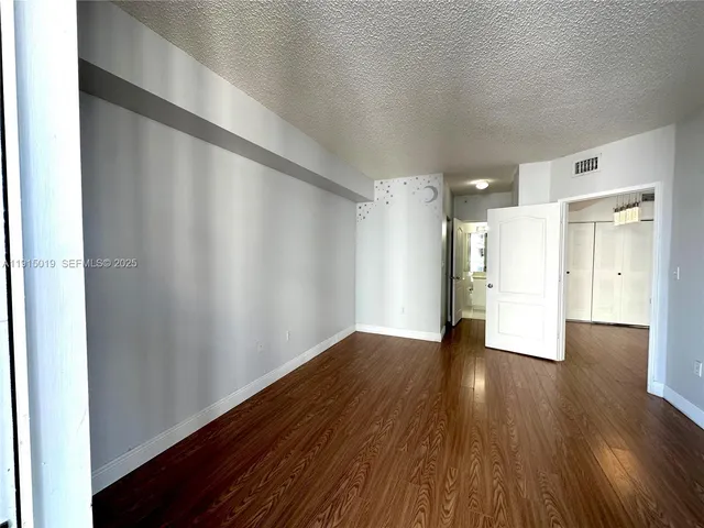 a view of an empty room with wooden floor