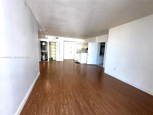 a view of empty room with wooden floor and windows