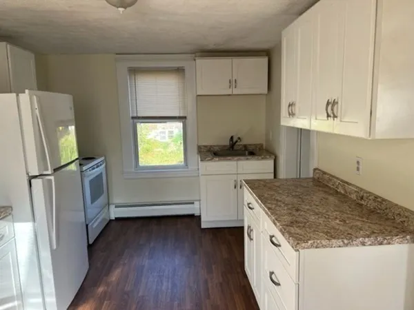 a kitchen with granite countertop a sink stove and refrigerator
