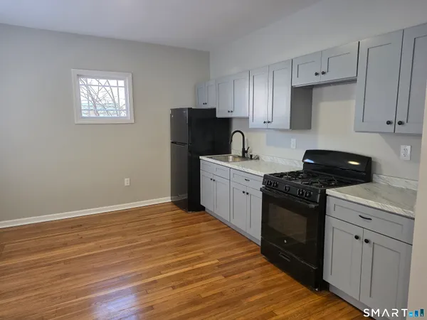 a kitchen with granite countertop a refrigerator stove and sink