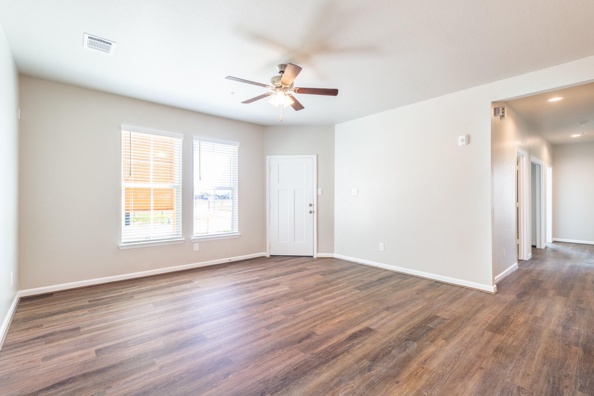 115 Park Place Circle, Unit B Waller, TX 77484 - Photo 7 of 24 a view of an empty room with wooden floor and a window