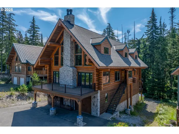 a front view of a house with a wooden deck and furniture