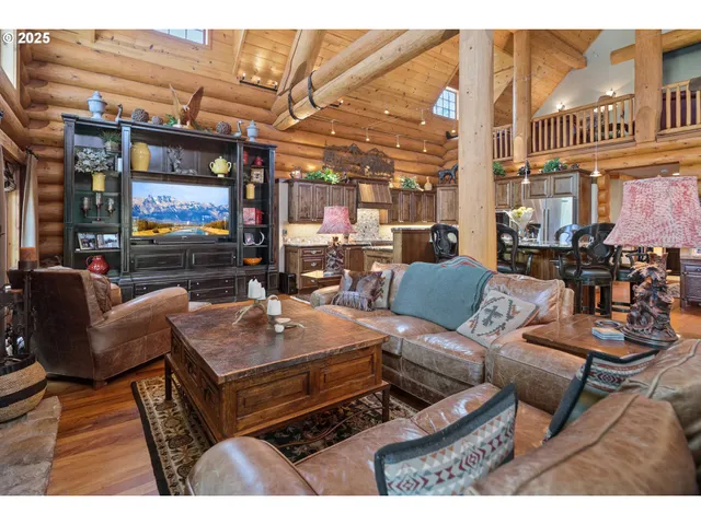 a living room with furniture a large window and chandelier