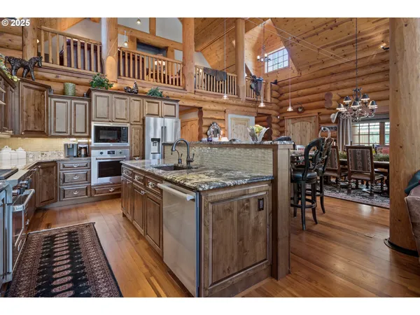 a kitchen with stainless steel appliances granite countertop a stove and a wooden floors
