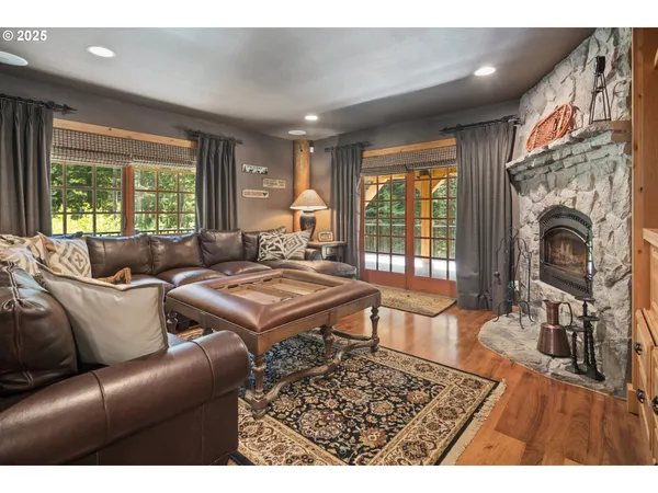 a living room with furniture a fireplace and large windows