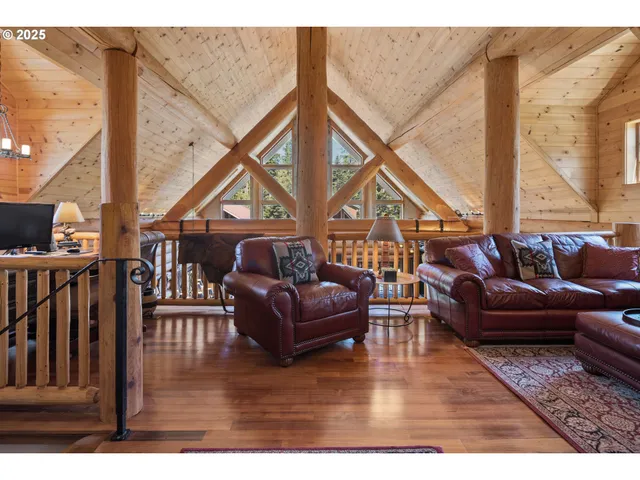a living room with furniture a large window and wooden floor