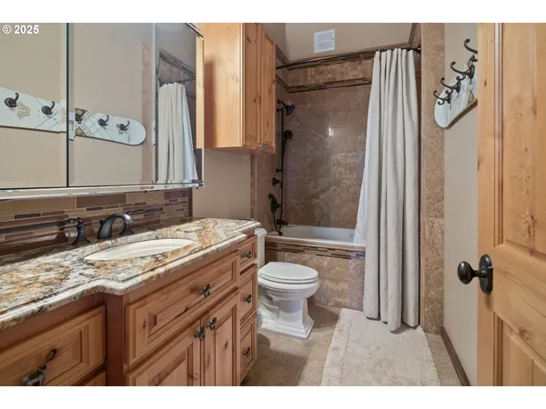 a bathroom with a granite countertop sink toilet and shower