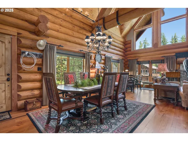 a dining room with furniture a chandelier and wooden floor