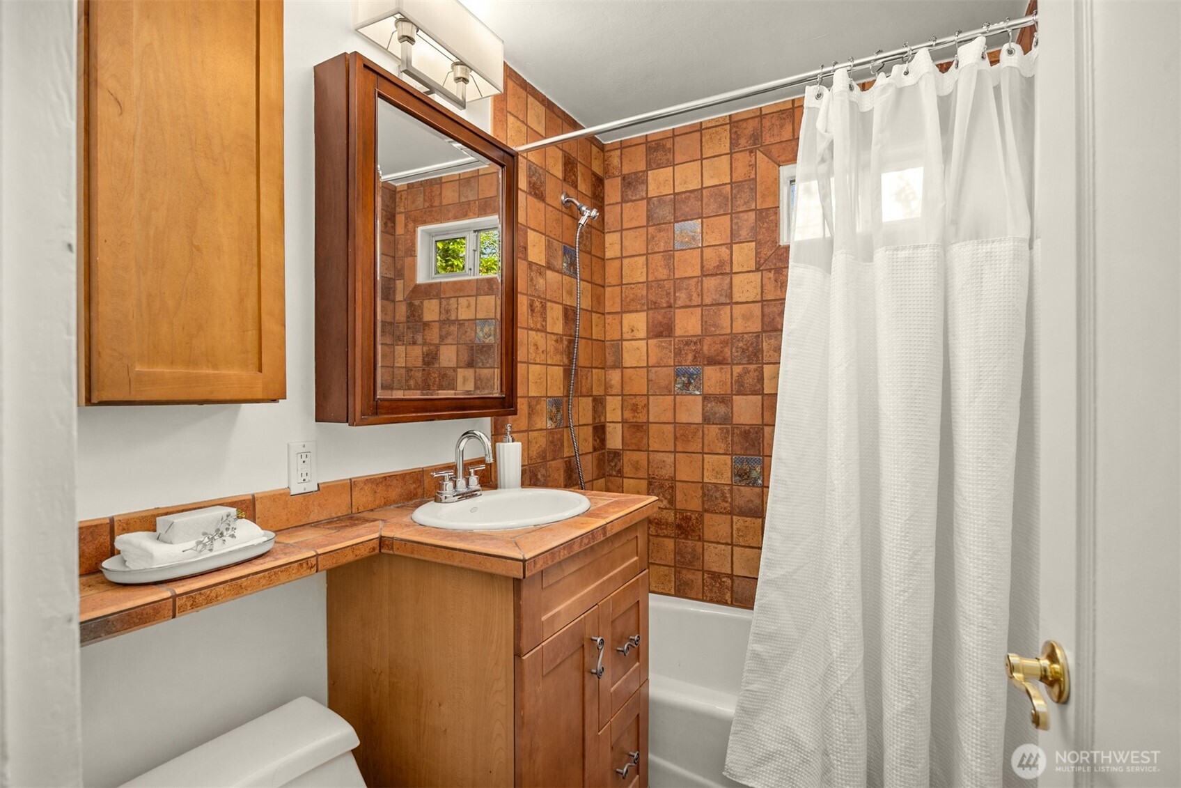 5606 Northeast 59th Street Seattle, WA 98105 - Photo 14 of 28 a bathroom with a sink and a mirror