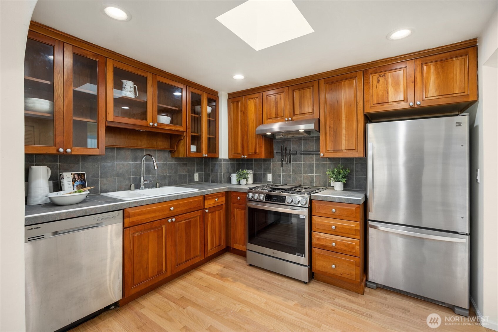 5606 Northeast 59th Street Seattle, WA 98105 - Photo 10 of 28 a kitchen with stainless steel appliances granite countertop a refrigerator sink and cabinets