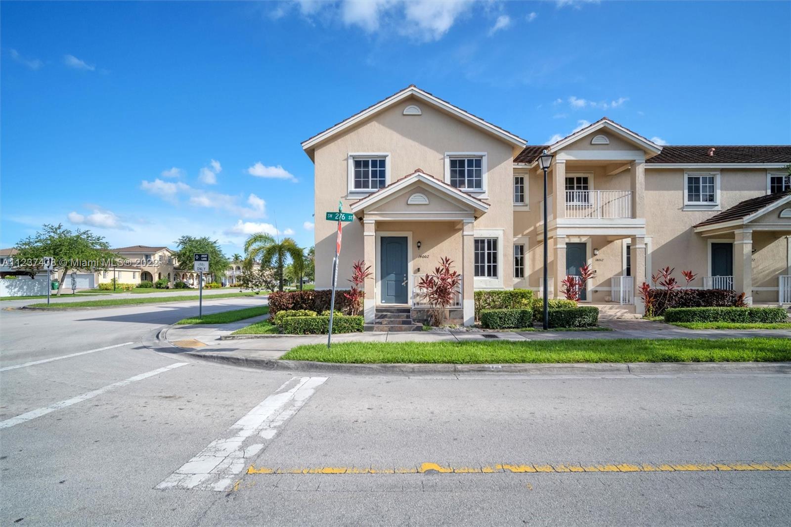 a front view of a house with a yard and trees