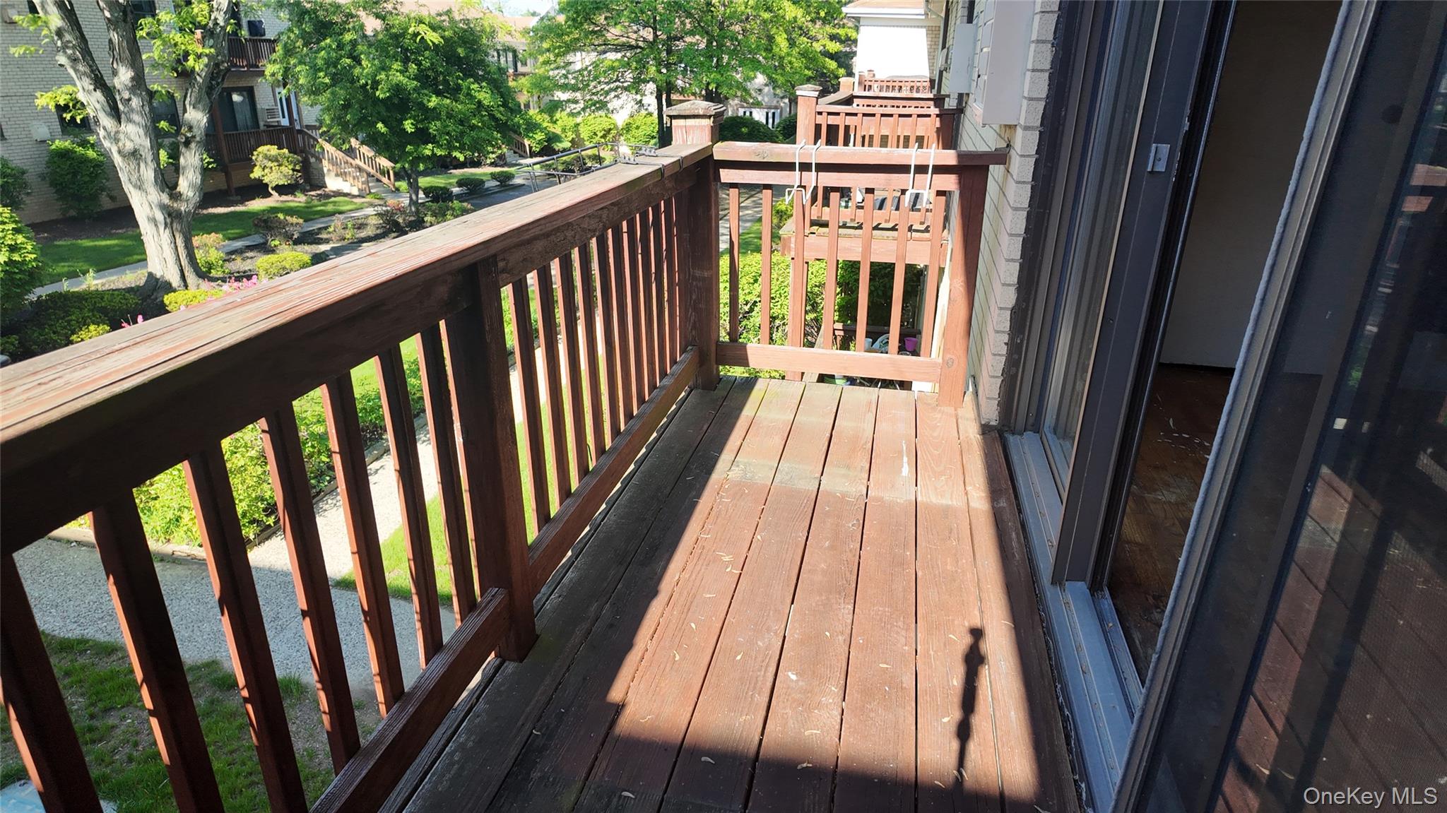 a view of balcony with wooden floor and fence