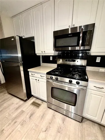 a kitchen with a stove a microwave and refrigerator