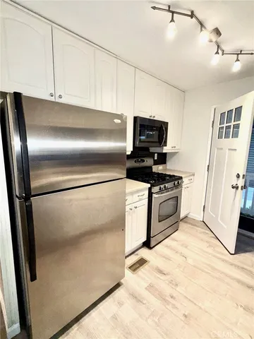 a kitchen with stainless steel appliances and white cabinets
