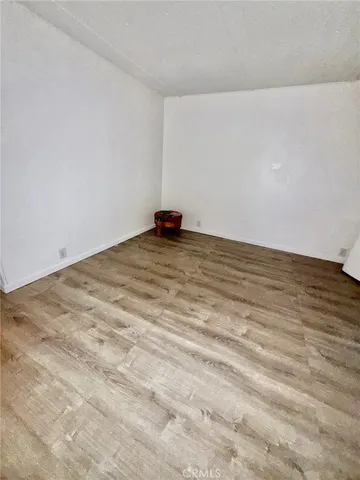a view of a room with an empty space and wooden floor