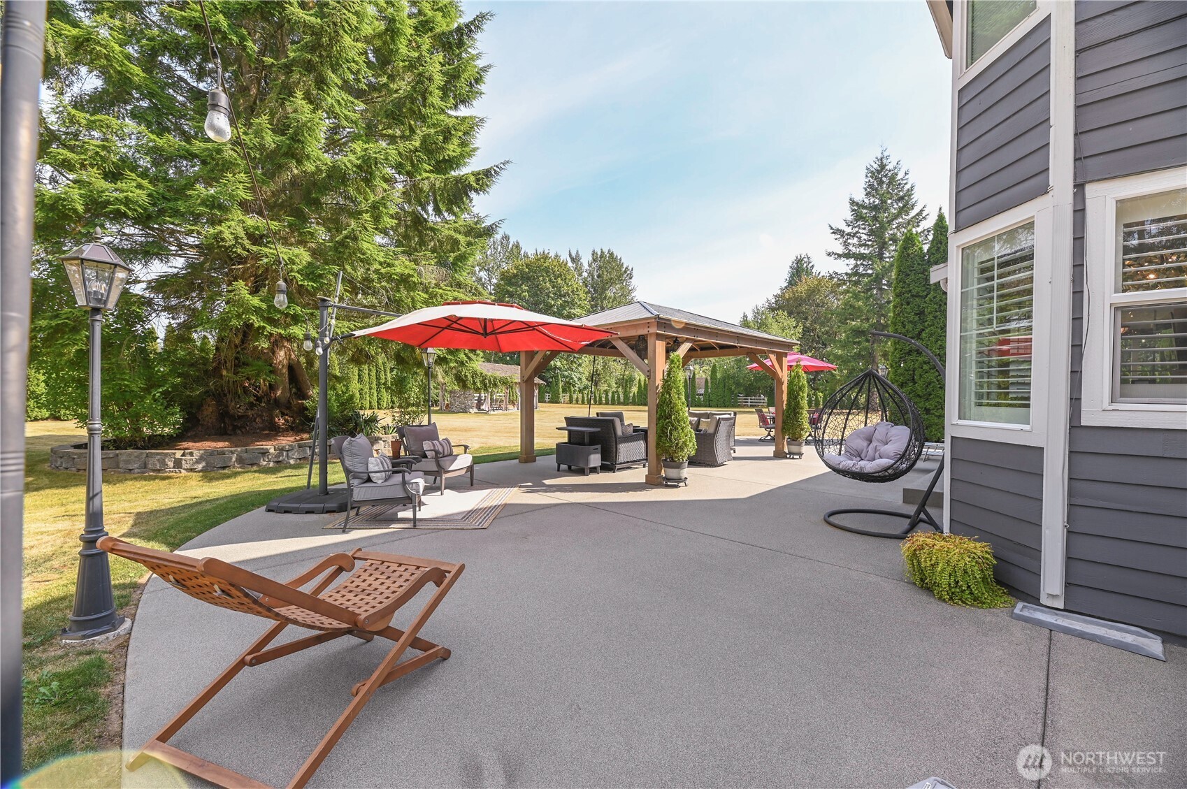12523 Woods Lake Road Monroe, WA 98272 - Photo 32 of 40 a view of a patio with a table and chairs under an umbrella