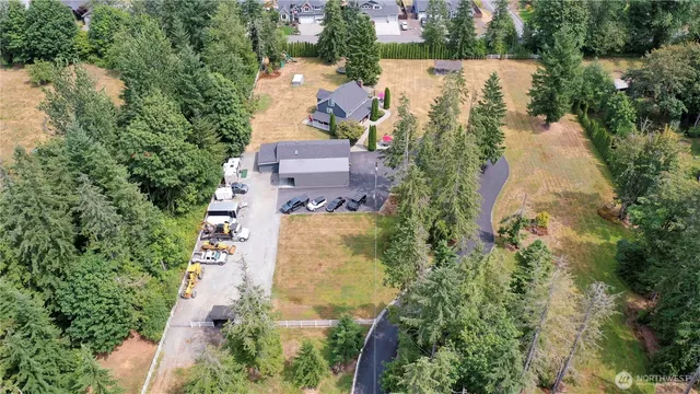 an aerial view of residential house with outdoor space and trees all around