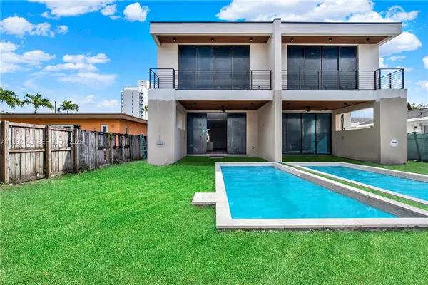 a view of a house with a swimming pool and a yard