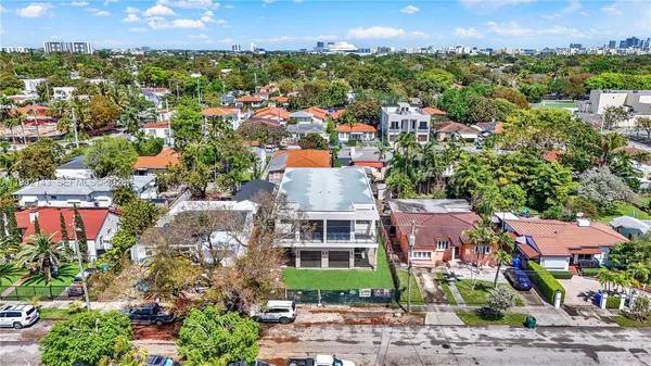 an aerial view of a city with lots of residential buildings and mountain view in back