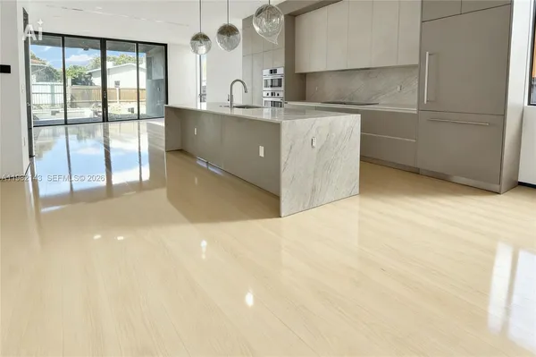 a kitchen with kitchen island a sink a stove and a refrigerator