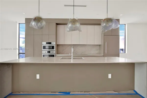 a kitchen with kitchen island stainless steel appliances a sink and cabinets