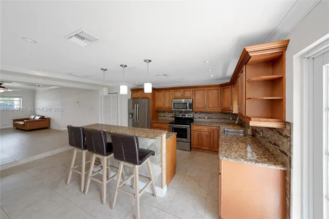 a kitchen with stainless steel appliances granite countertop a stove a sink and a microwave