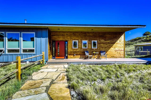 a view of a house with a yard and a tree