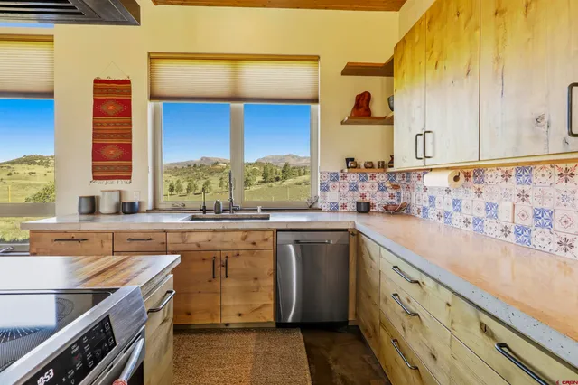 a living room with furniture a rug and a floor to ceiling window