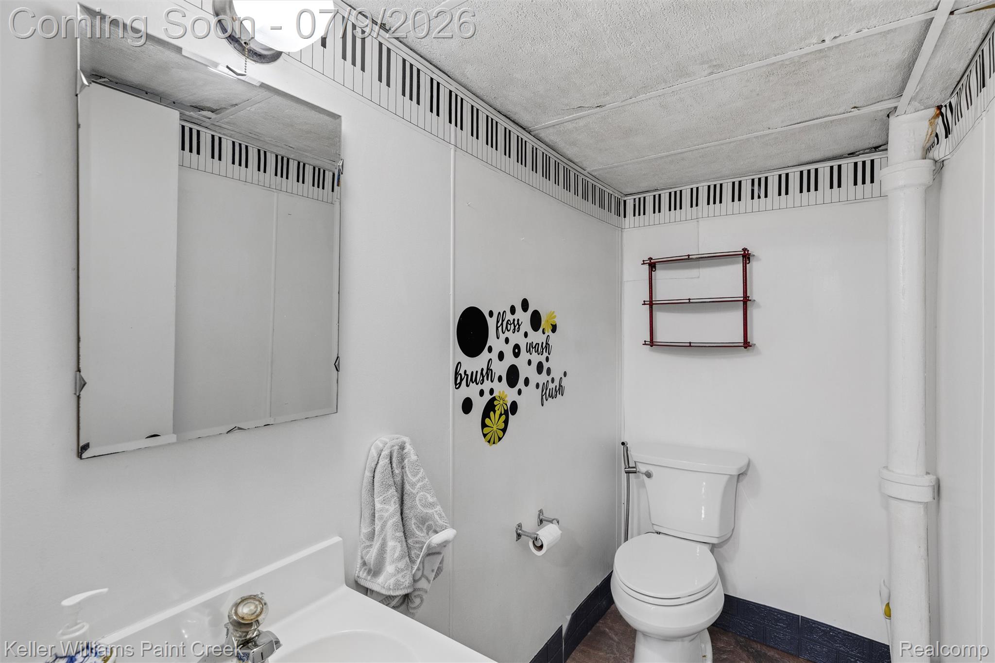 2731 Crooks Road Royal Oak, MI 48073 - Photo 24 of 34 Compact bathroom featuring white wall paneling with a piano key border, a built-in toilet, and a wall-mounted medicine cabinet
